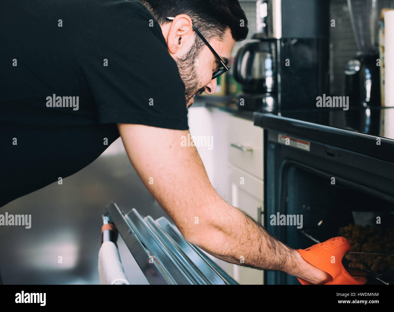 Man removing food from oven Stock Photo
