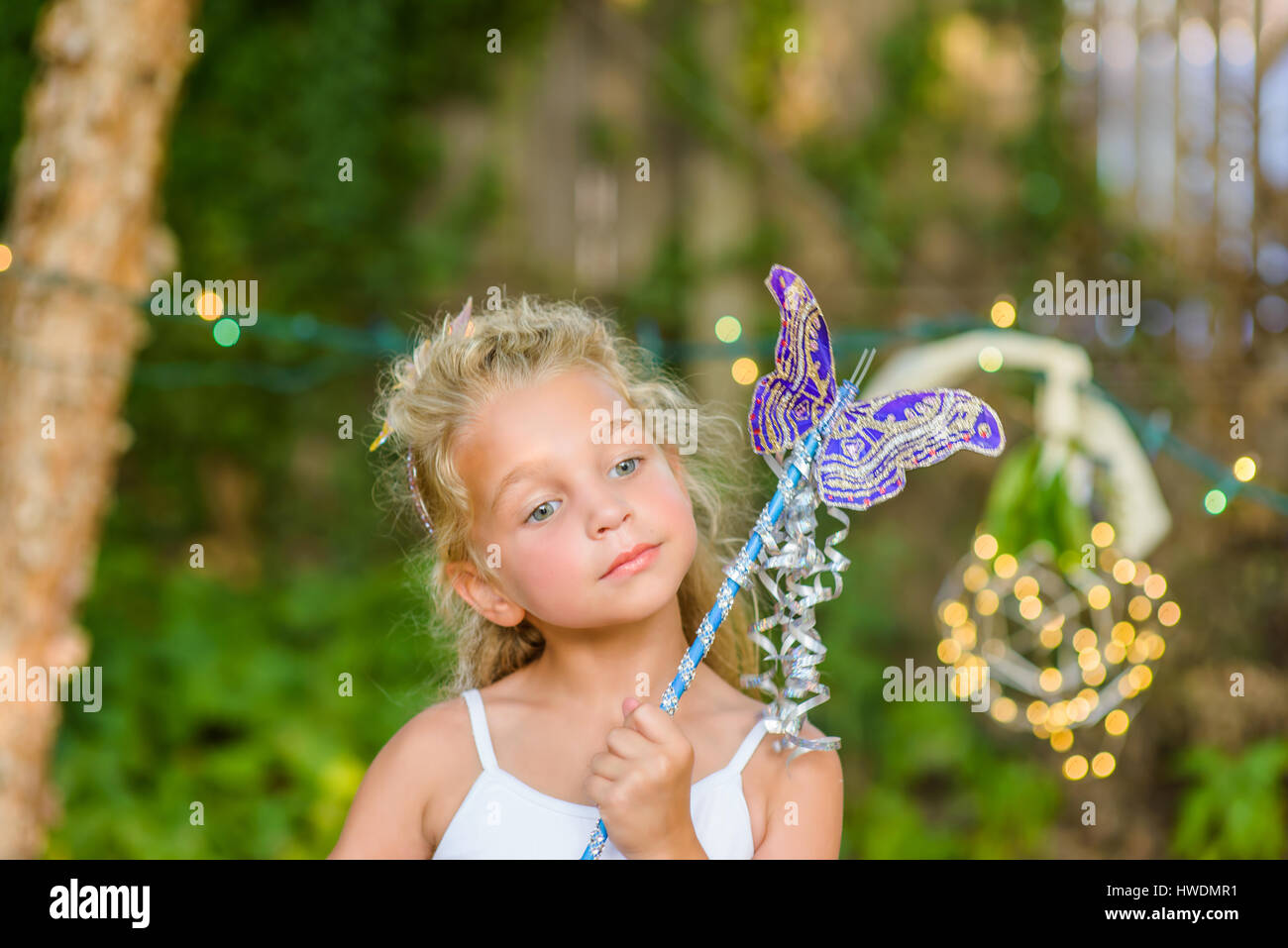 Portrait of young girl holding butterfly wand Stock Photo