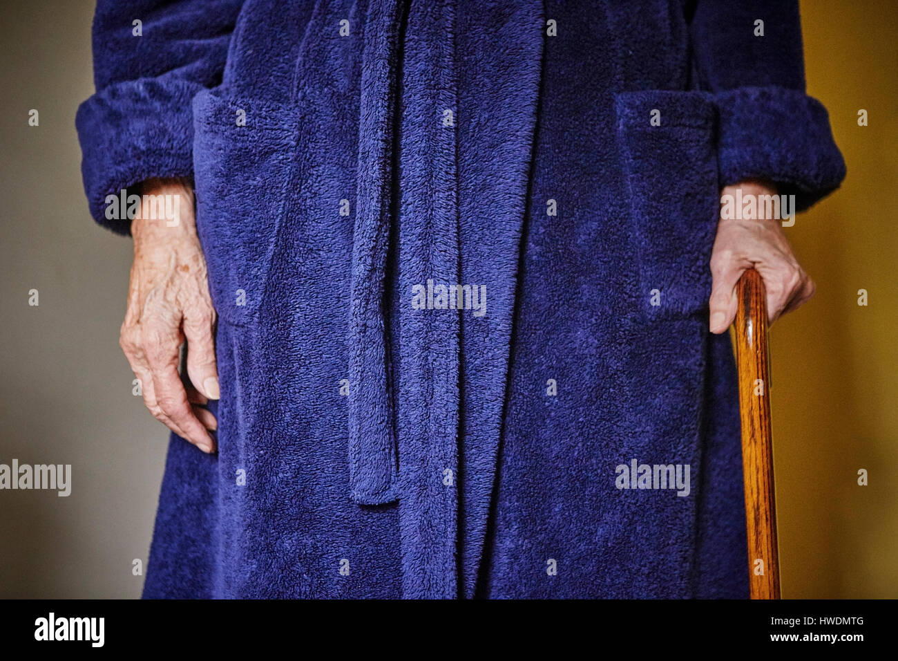 Senior woman standing with walking cane, mid section Stock Photo