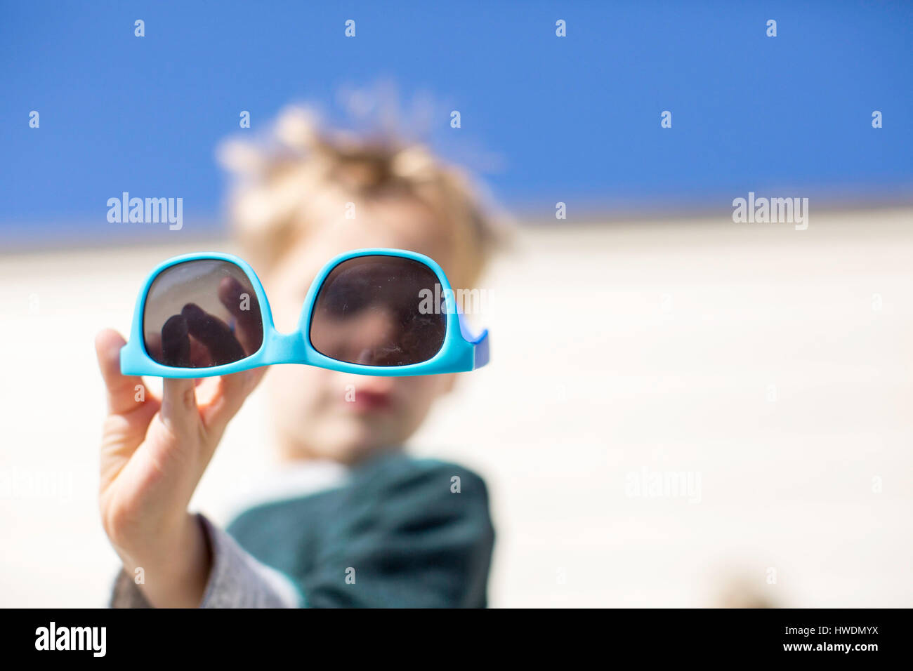 Boy holding up sunglasses Stock Photo