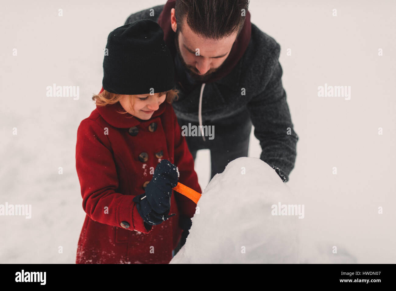 Father and daughter making snowman Stock Photo