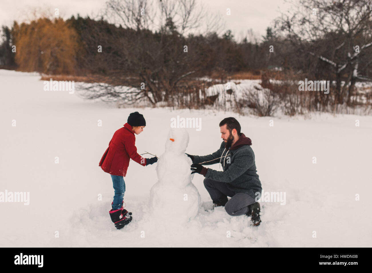 Father and daughter making snowman Stock Photo