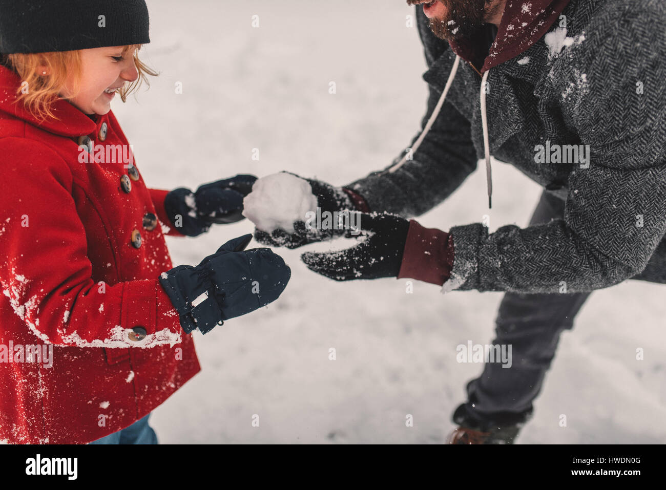 Father and daughter playing in snow Stock Photo