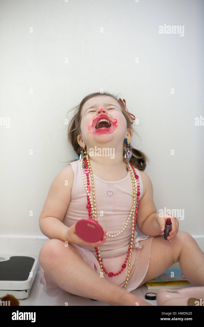 Girl caught out playing with lipstick Stock Photo