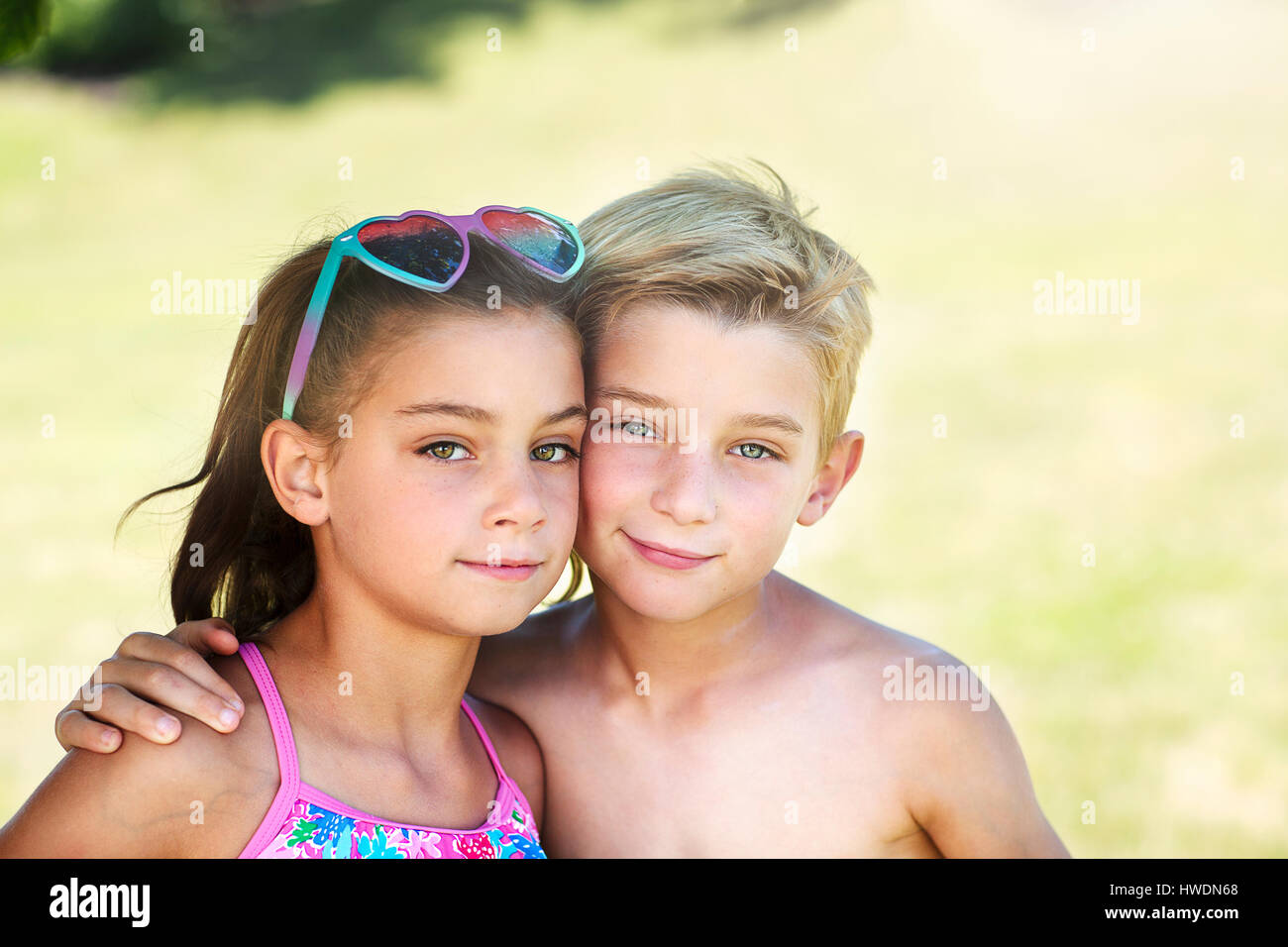 Summer portrait of boy with arm around twin sister Stock Photo