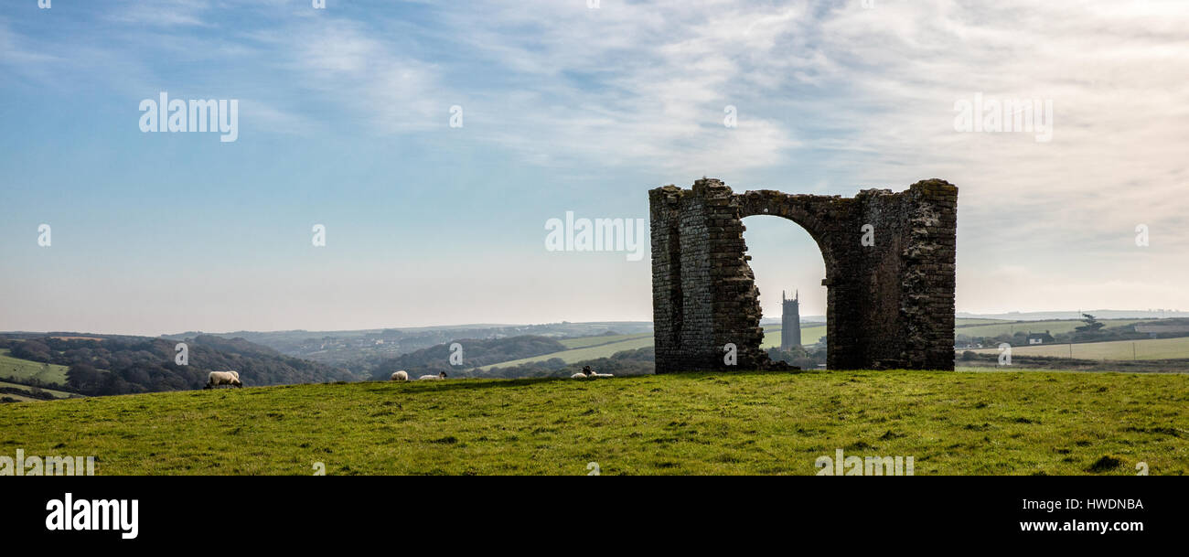 Stoke Barton church tower seen through the arch of ruined Pleasure House Folly on the cliffs above Hartland Quay in north Devon UK Stock Photo