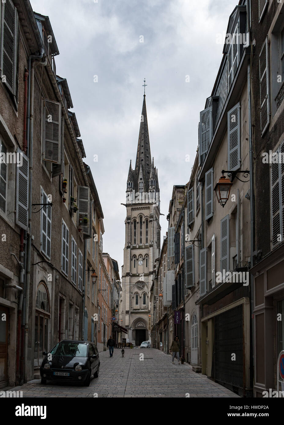 The church tower of the Eglise Saint Martin as seen from a narrow street in Pau, France Stock Photo