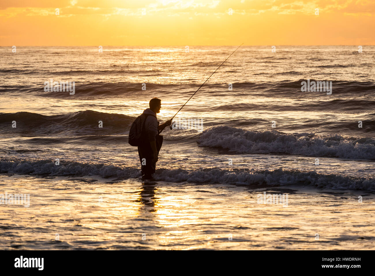 NC00912-00...NORTH CAROLINA - Surf fishing during sunrise over the Atlantic Ocean at the Surf City Pier. Stock Photo