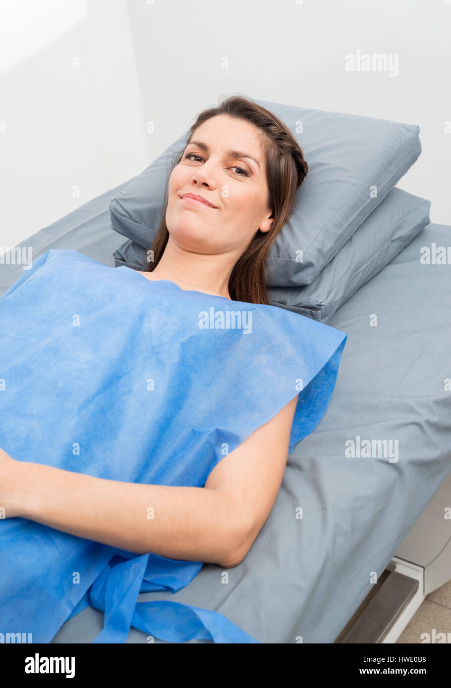 Female Patient In Protective Clothing Lying On Hospital Bed Stock Photo