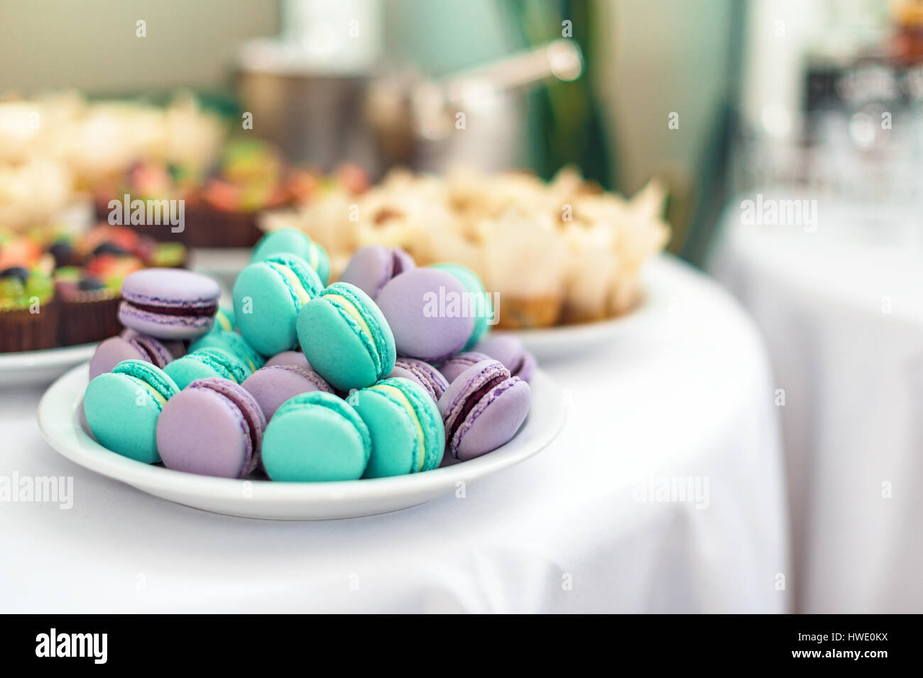 Turquoise and violet macarons. Wedding cakes on the table. Sweet desserts. Selective focus Stock Photo