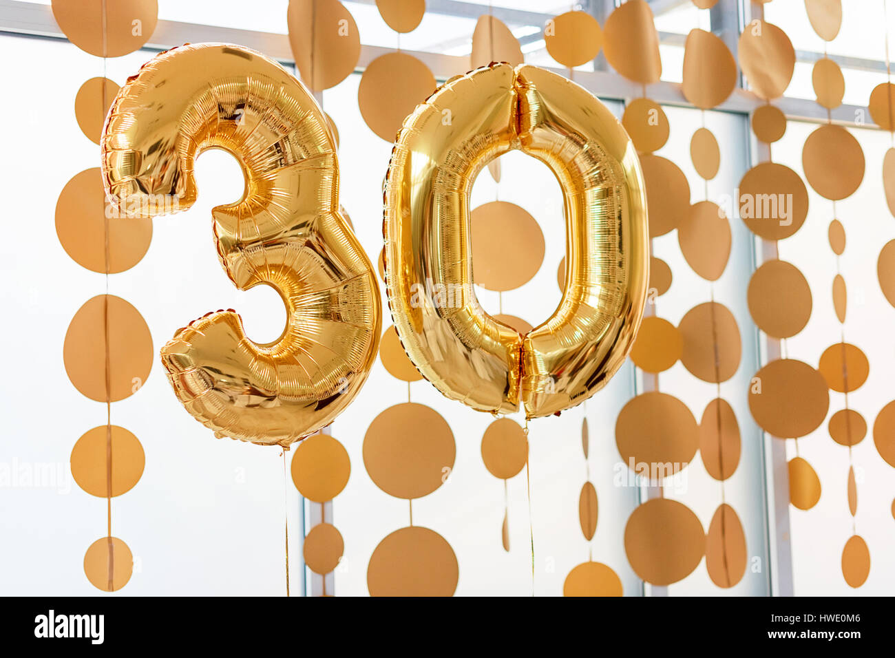 Golden balloons with ribbons - Number 30. Party decoration, anniversary sign for happy holiday, celebration, birthday, carnival, new year. Metallic design balloon. Stock Photo