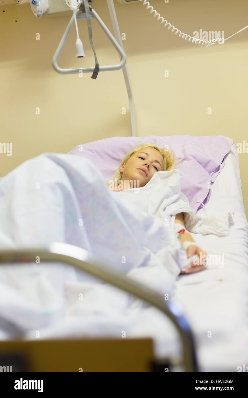 Bedridden female patient recovering after surgery in hospital care