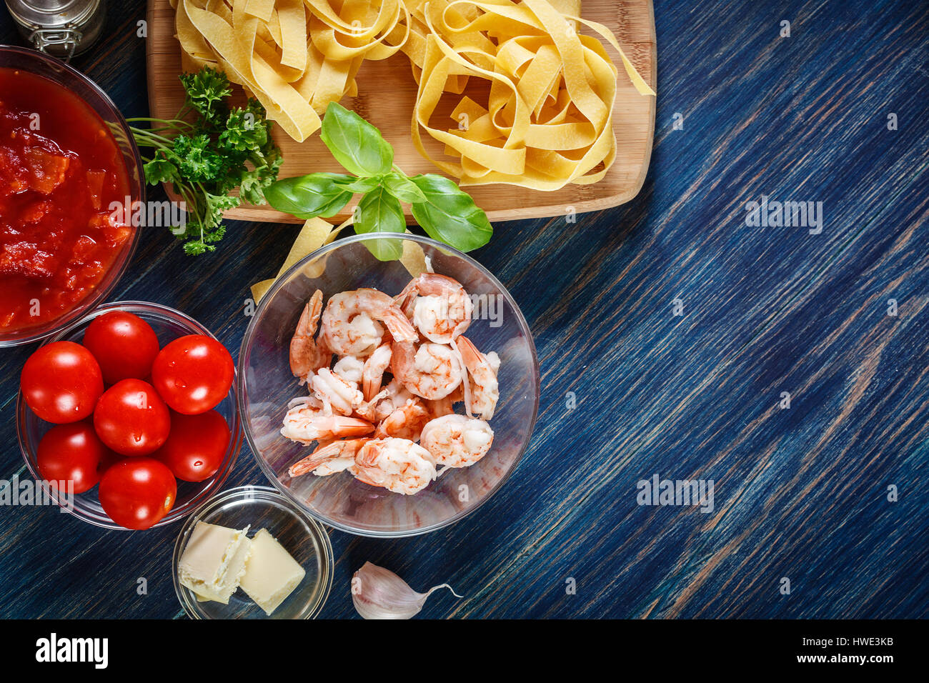 Ingredients ready for preparing pappardelle pasta with shrimp, tomatoes