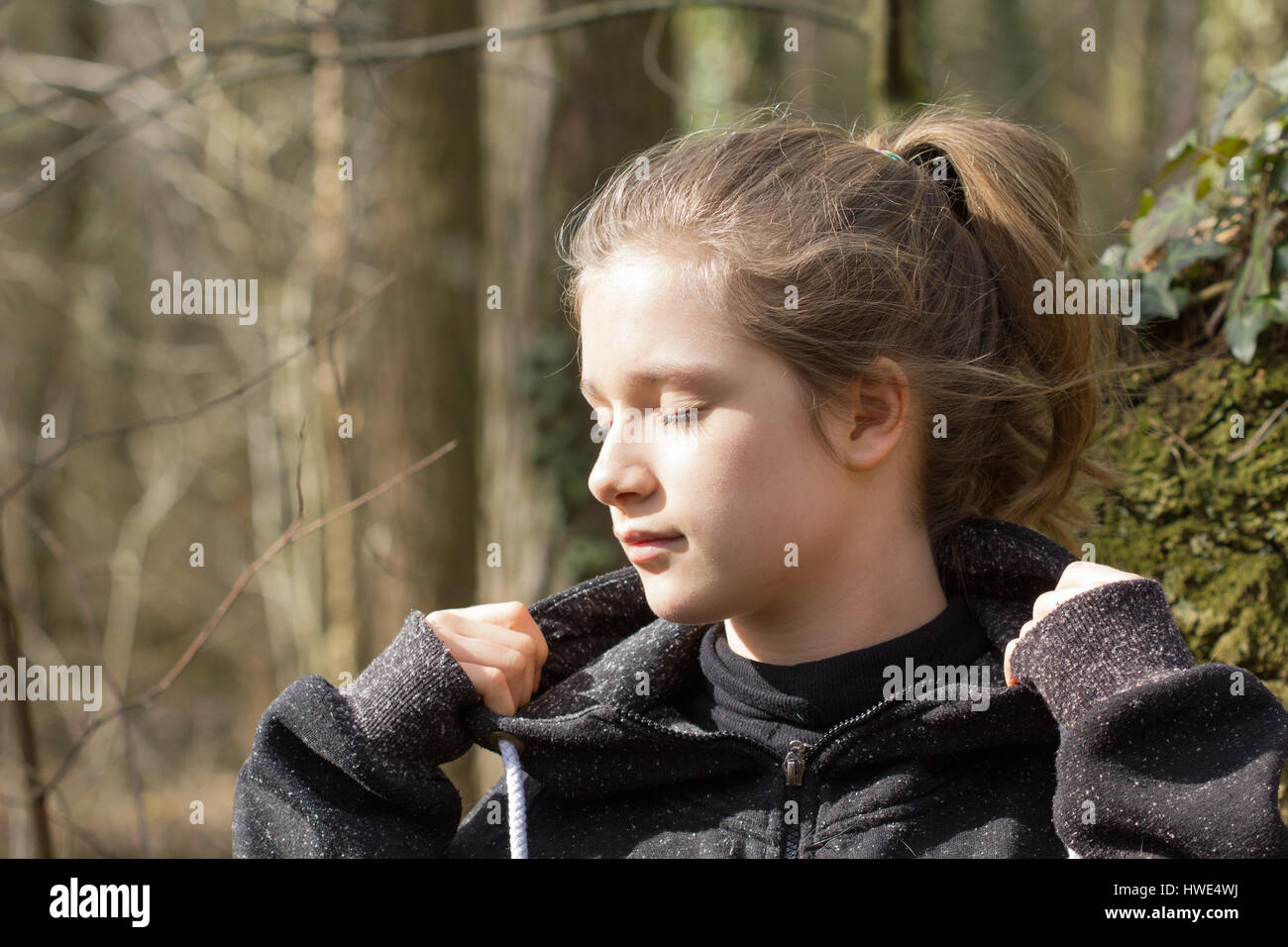 A pretty girl with eyes closed in forest Stock Photo - Alamy