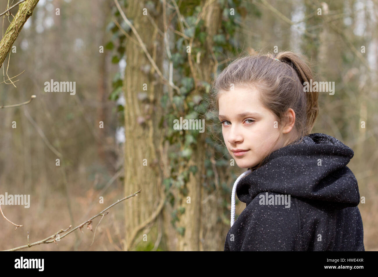 A pretty girl in the forest looks back Stock Photo