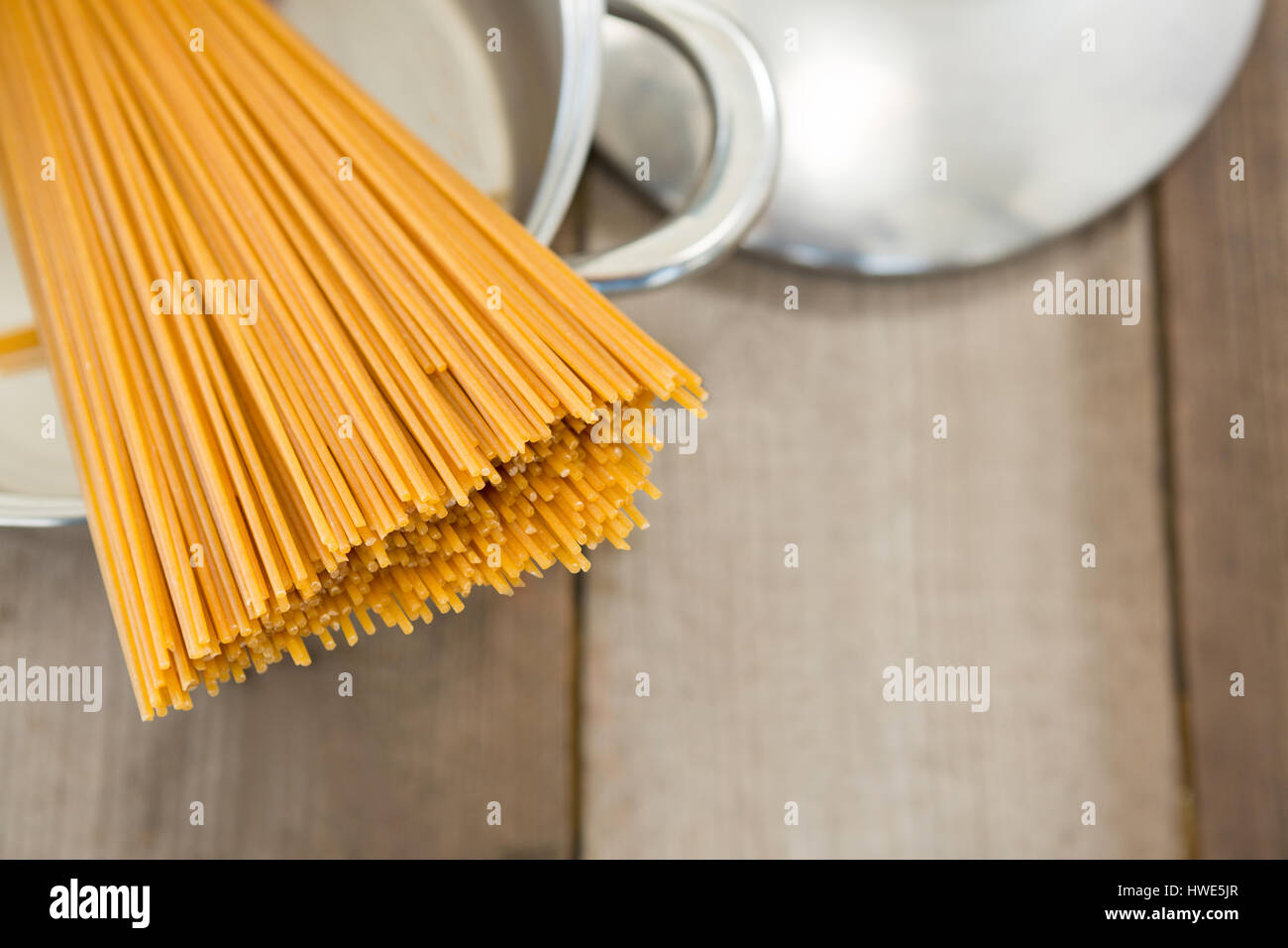 Spaghetti pasta in utensil on wooden surface Stock Photo Alamy