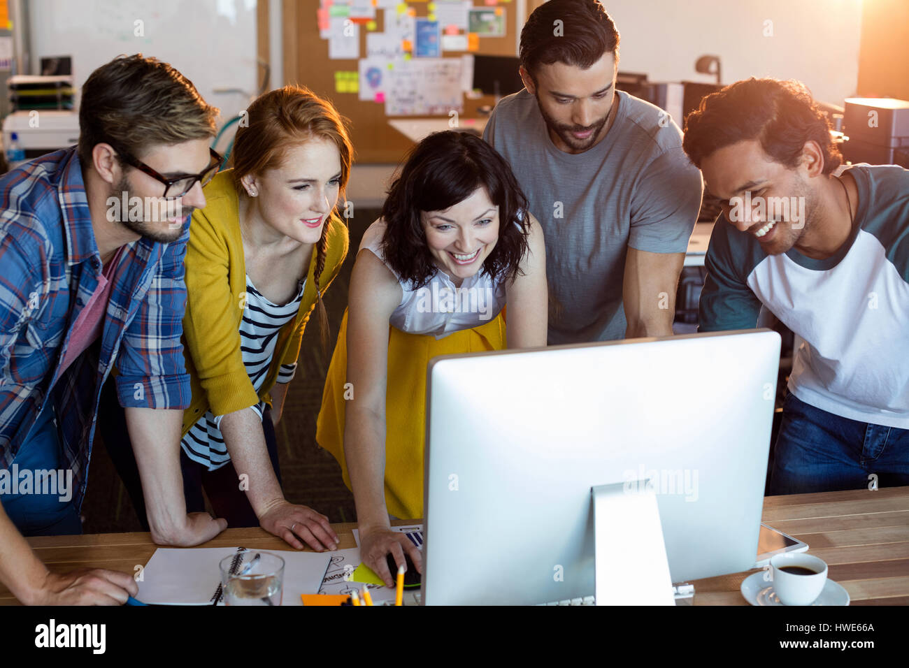 Team Working Together Computer Smiling creative business team working together on desktop pc in office ...