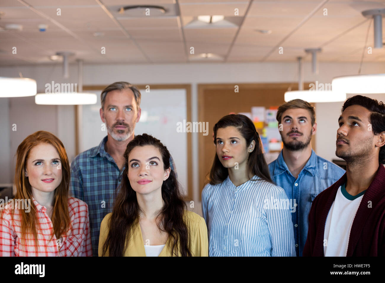 Creative business team standing together and looking up in office Stock ...