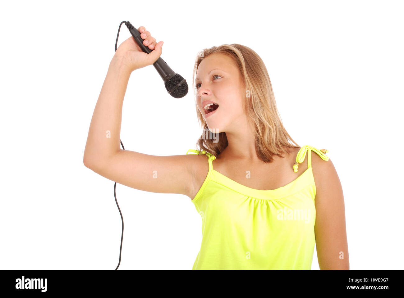 Happy young beautiful girl singing with microphone isolated on white