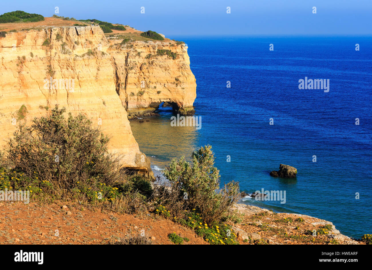 Natural arch in cliff. Summer Atlantic rocky coast view near beach Praia da Afurada (Lagoa, Algarve, Portugal). Stock Photo