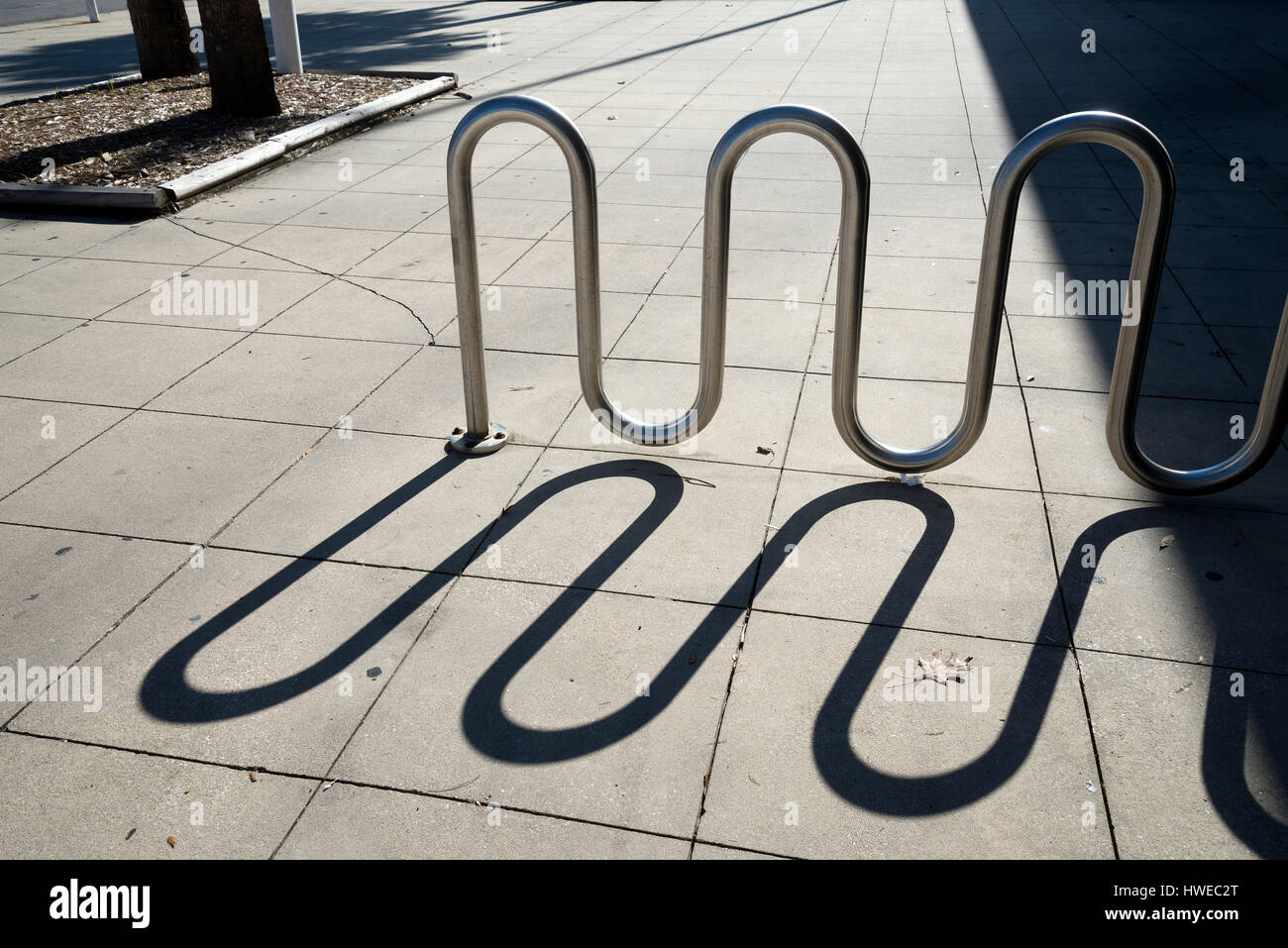 Shadow of a bicycle rack on a sidewalk Stock Photo Alamy