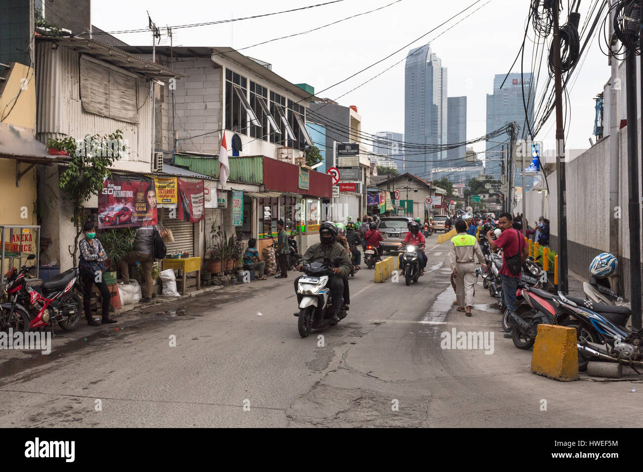 JAKARTA, INDONESIA - JANUARY 27, 2017: Local street contrasts with the tall modern office buildings in Jakarta downtown where life is still organized  Stock Photo