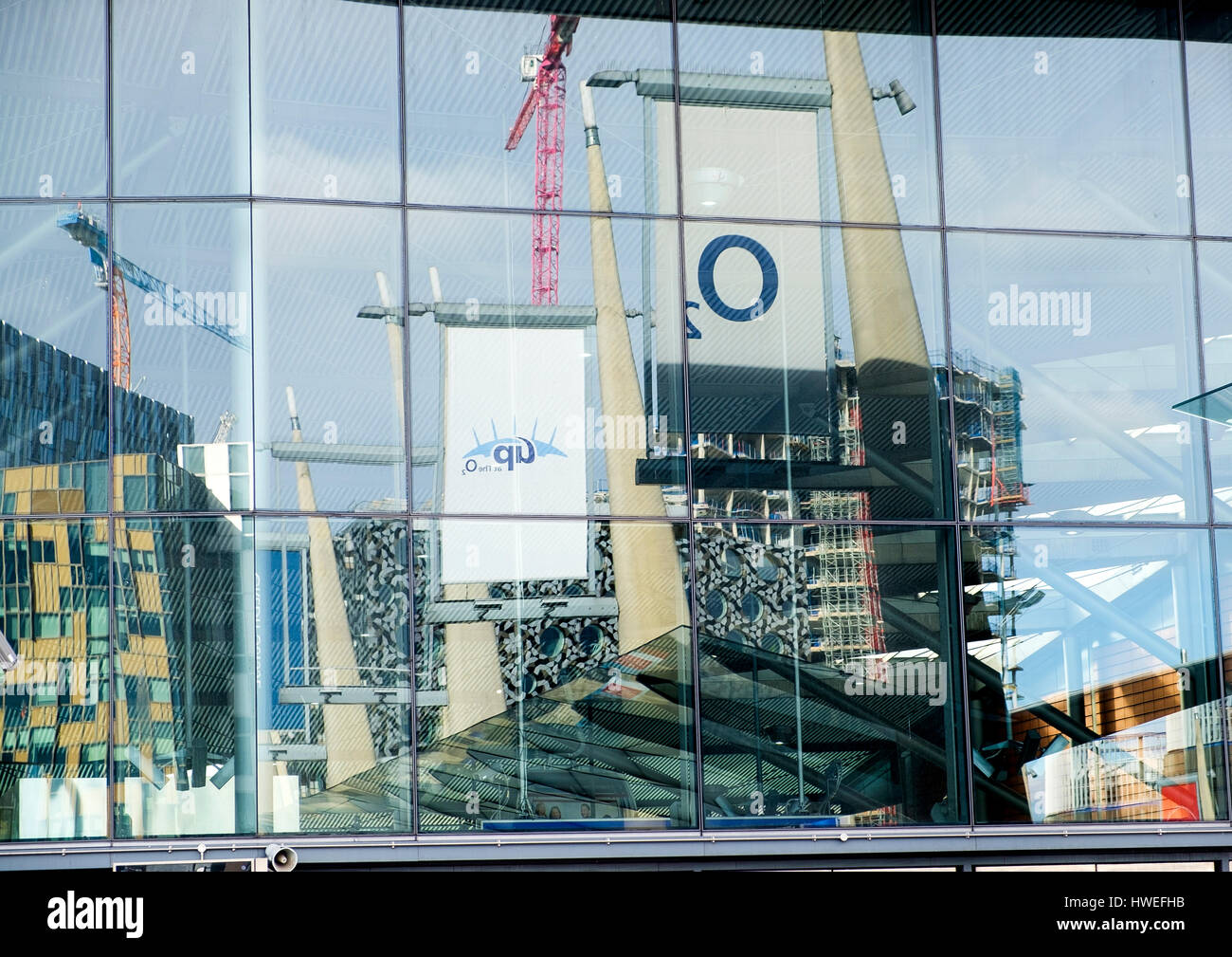Abstract reflections of Peninsula Square in the glass of North Greenwich station Stock Photo