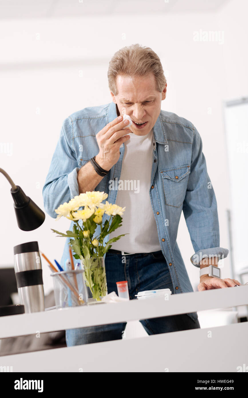 Serious male standing behind the table Stock Photo - Alamy