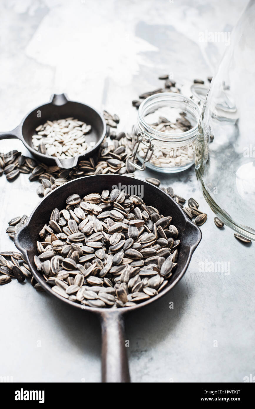 Studio shot, overhead view of sunflower seeds in pans and jars Stock Photo