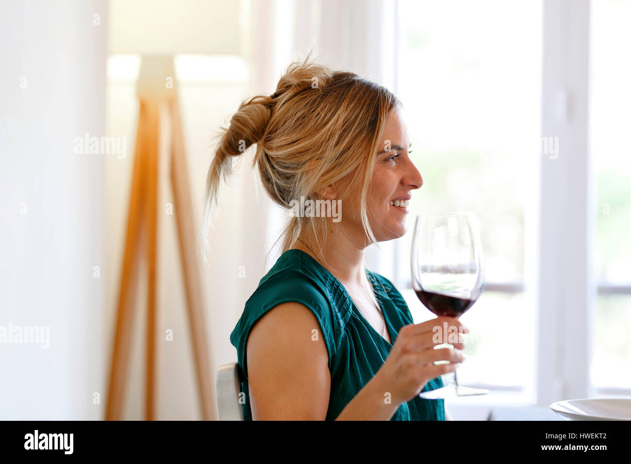 Woman at home, holding glass of wine, smiling Stock Photo - Alamy