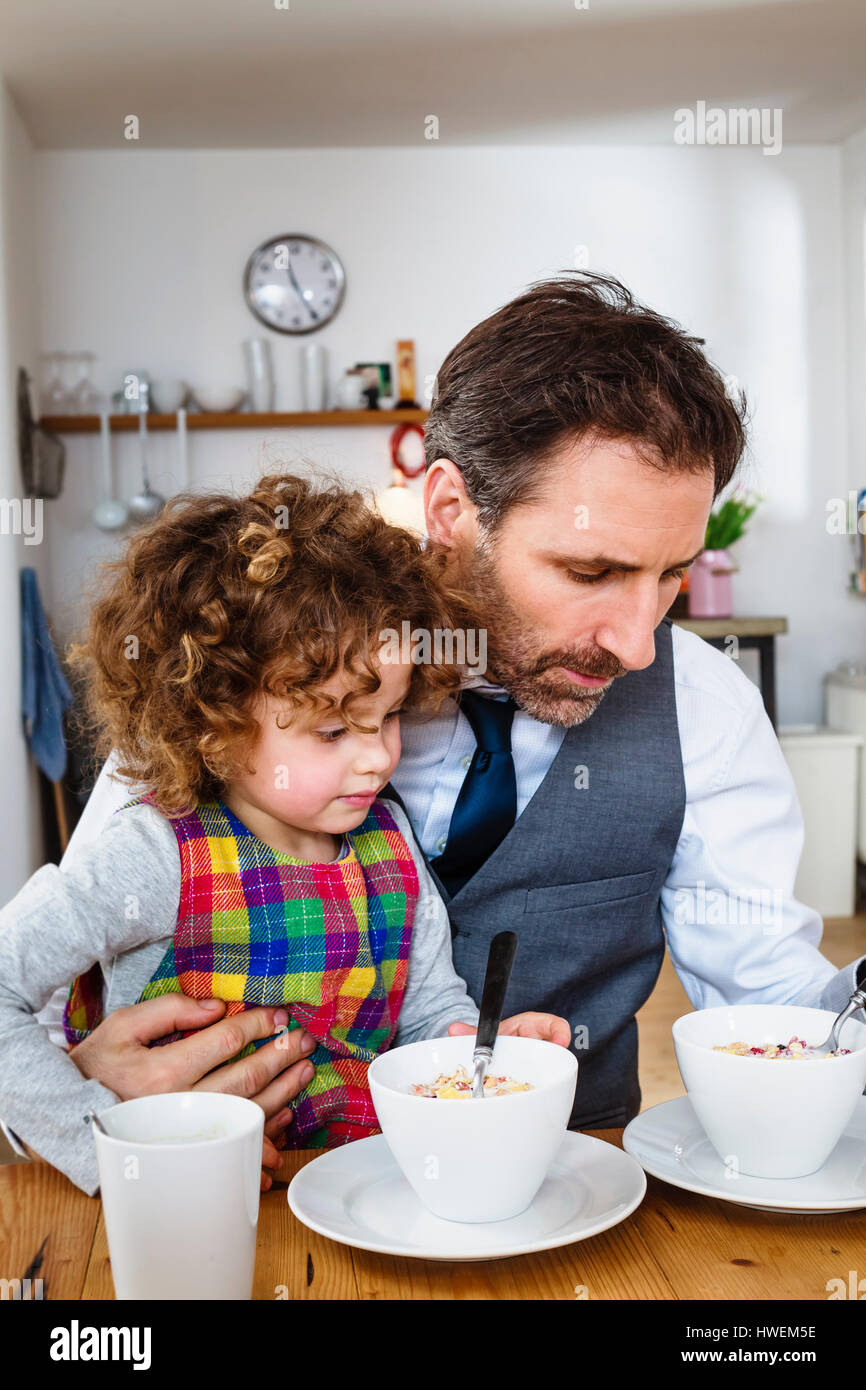 Man and daughter having cereal breakfast in kitchen Stock Photo