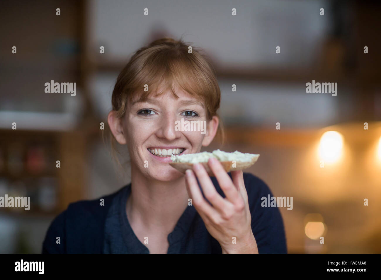 Young woman eating bread with cream cheese Stock Photo Alamy