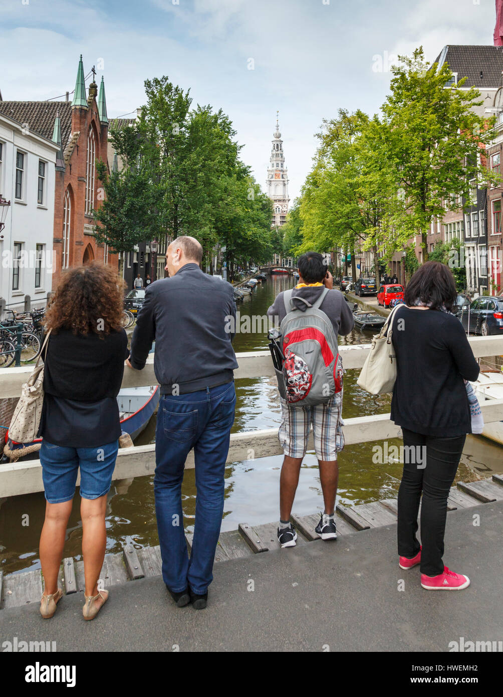 Tourists taking photographs of the Zuiderkerk from a bridge over the Groenburgwal canal in Amsterdam Stock Photo