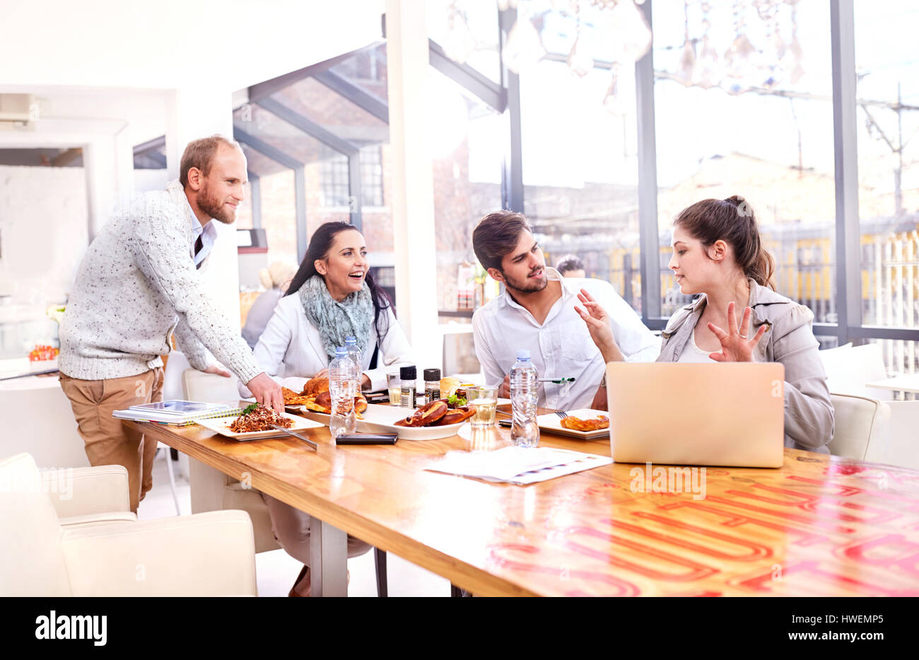 Businesswoman explaining to business team during working lunch in restaurant Stock Photo