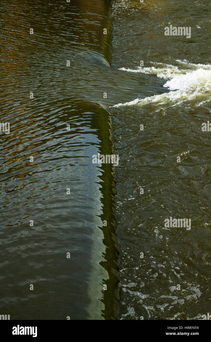 Water flowing over a small dam at Guadiana river with a large breach of stronger current just above Pulo do Lobo waterfall. Alentejo, Portugal. Stock Photo