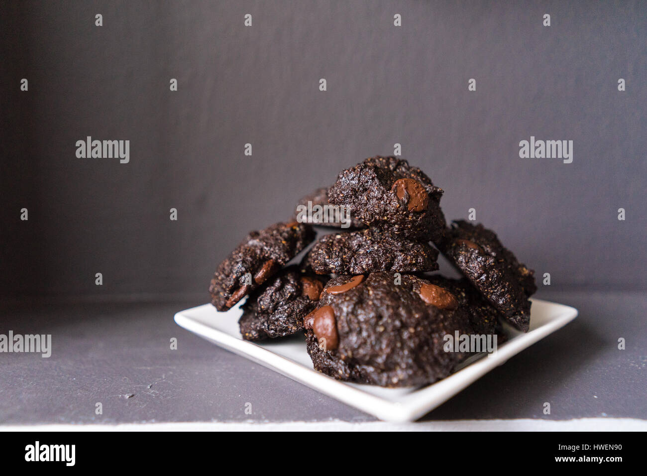 Stack of Vegan chocolate brownie cookie on white square plate Stock Photo