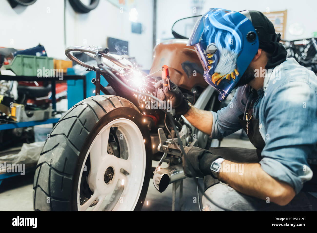 Mature man, working on motorcycle in garage Stock Photo Alamy