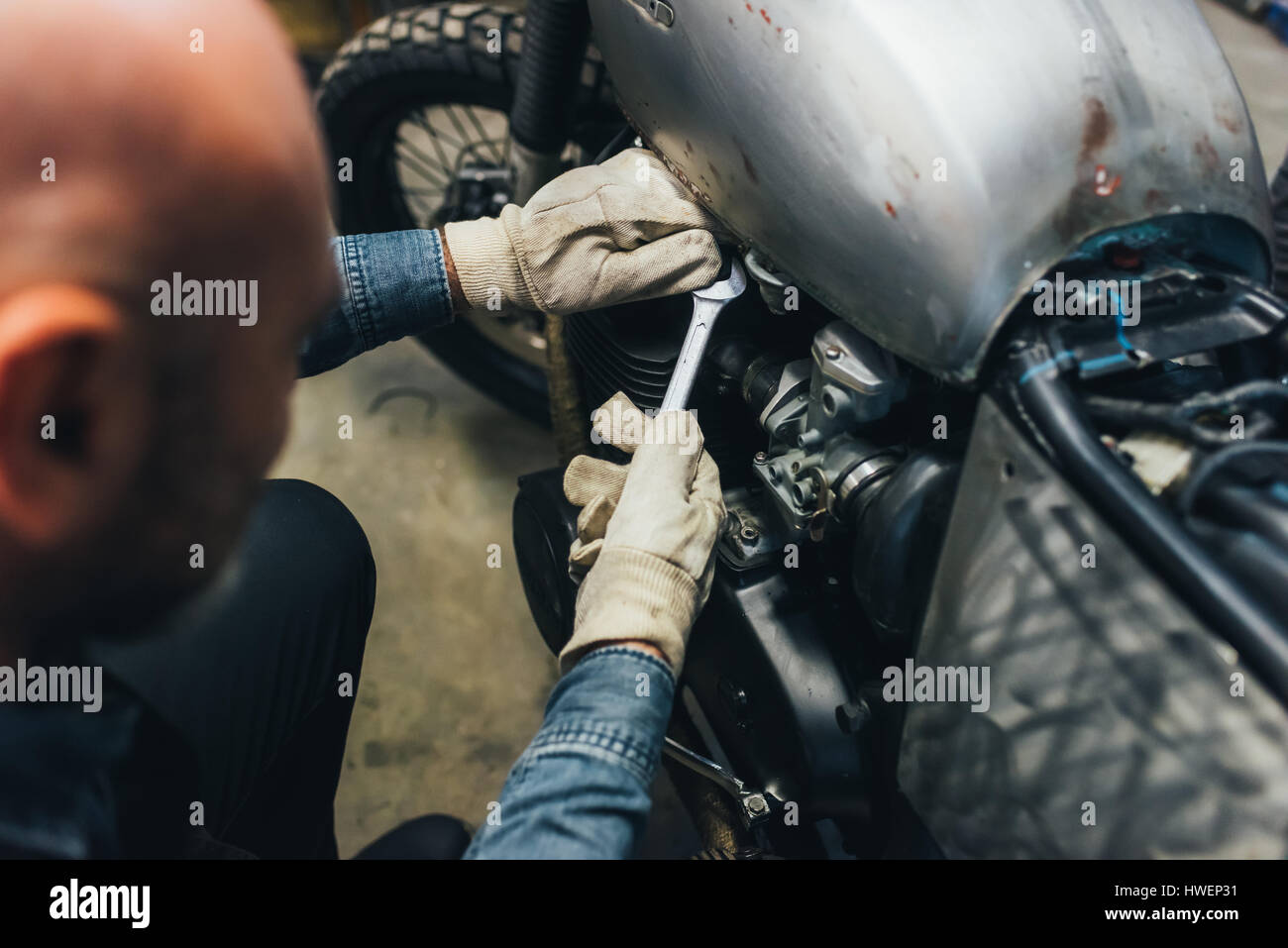 Mature man, working on motorcycle in garage Stock Photo