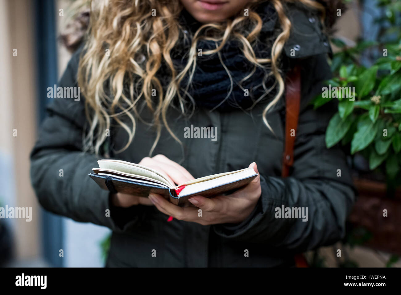 Cropped view of woman reading book, Milan, Italy Stock Photo