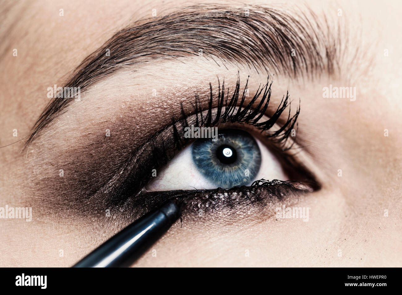 Close up of eyeliner being applied to young woman's eye Stock Photo
