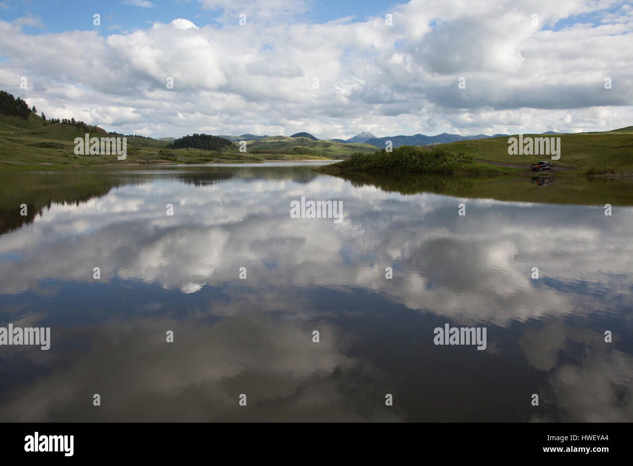 Clouds reflect in glassy waters of Bear Paw Lake in Hill County's