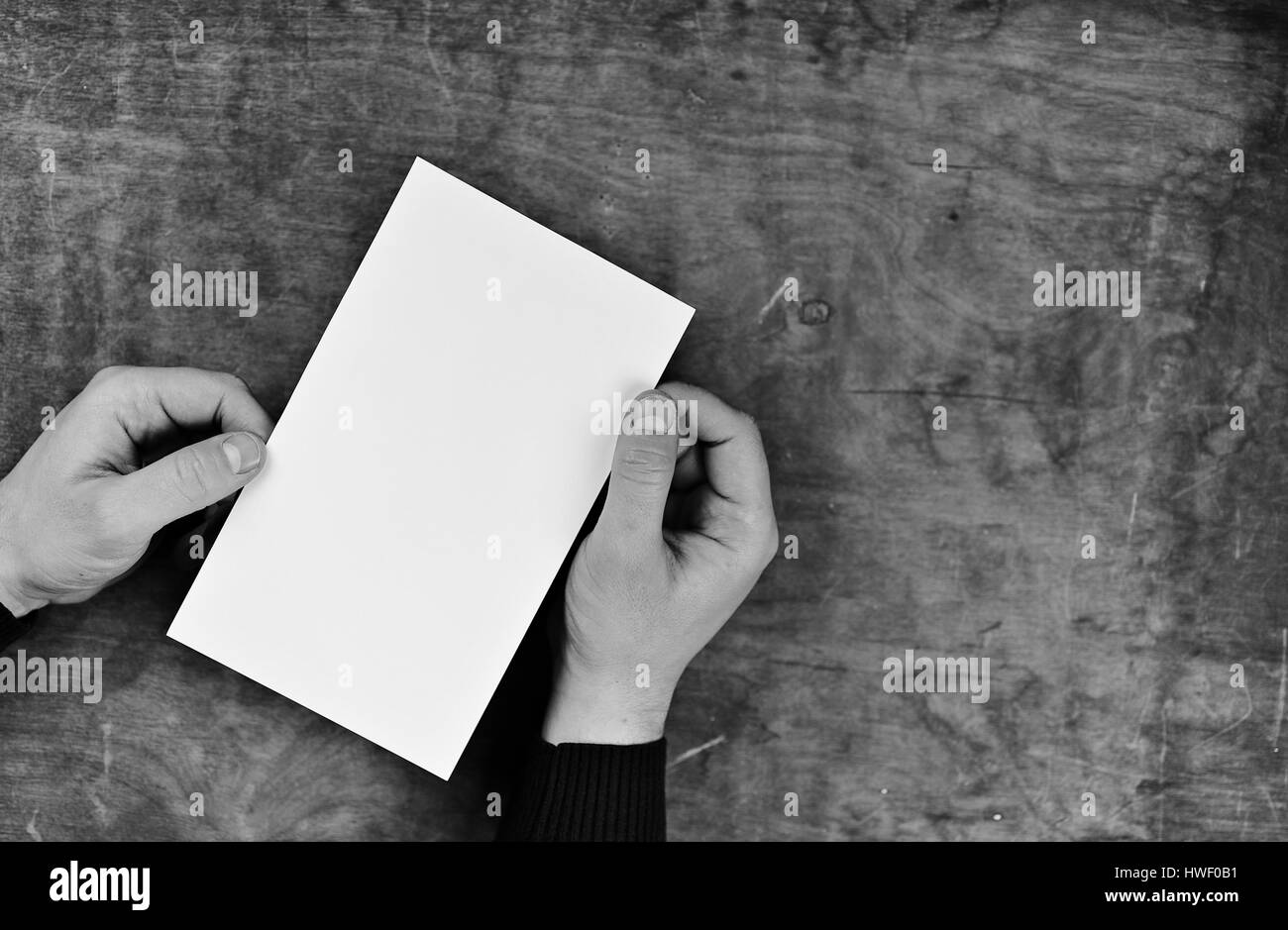 monochrome photo male hands holding a white blank sheet of paper Stock ...