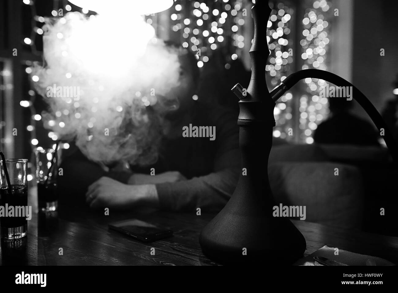 man holding hookah pipe and smoking in a night club Stock Photo - Alamy, image size:1300x956