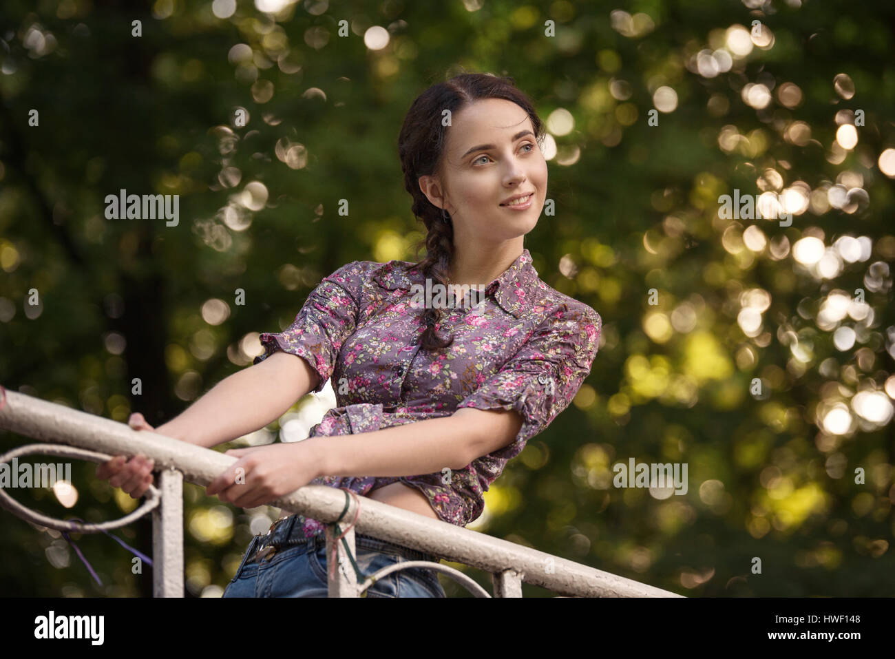 Portrait of young attractive smiling woman at summer green park on a ...