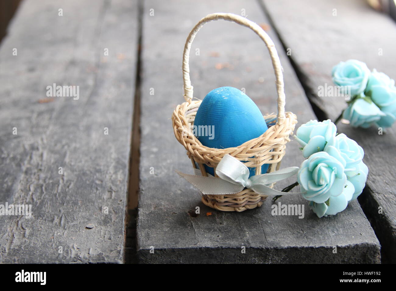 Easter background. Blue egg in basket on rustic table Stock Photo - Alamy