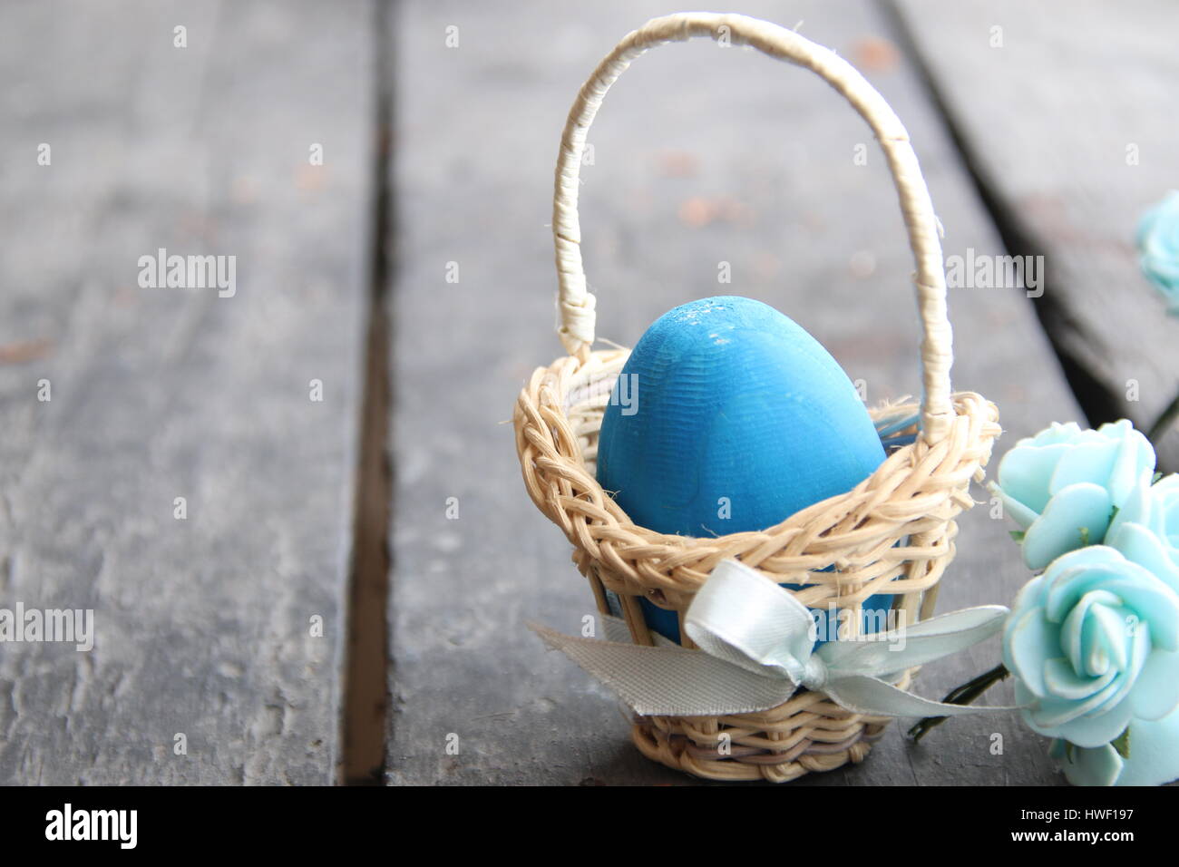 Easter background. Blue egg in basket on rustic table Stock Photo - Alamy