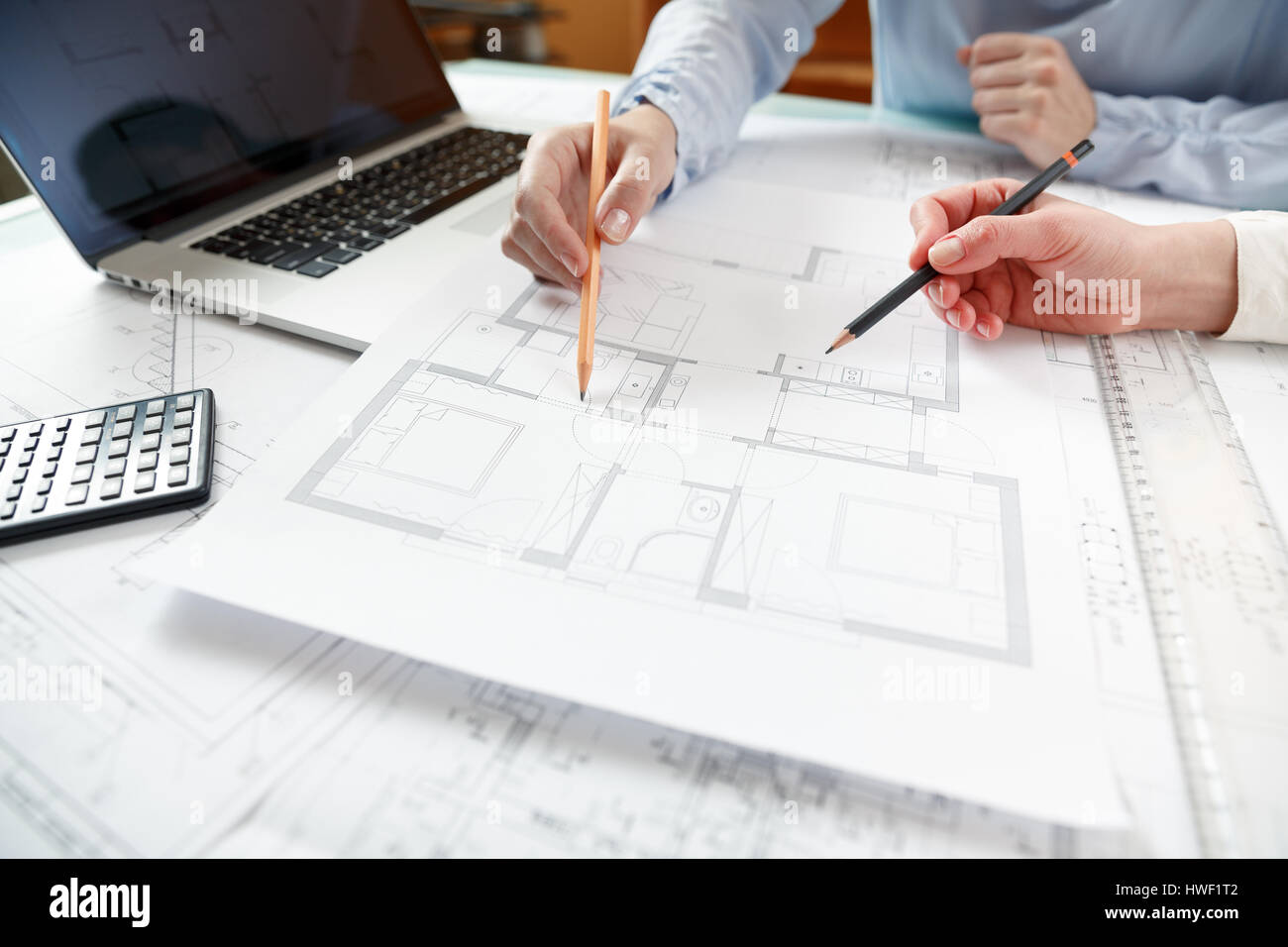 Young female architect and designer working on blueprint project of new ...