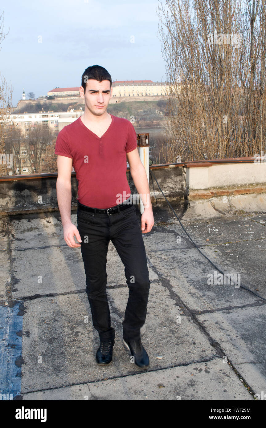 Young Man in a tight red shirt and black pants with his hands in the  pockets of trousers in the background Petrovaradin fortress and the Danube  River Stock Photo - Alamy