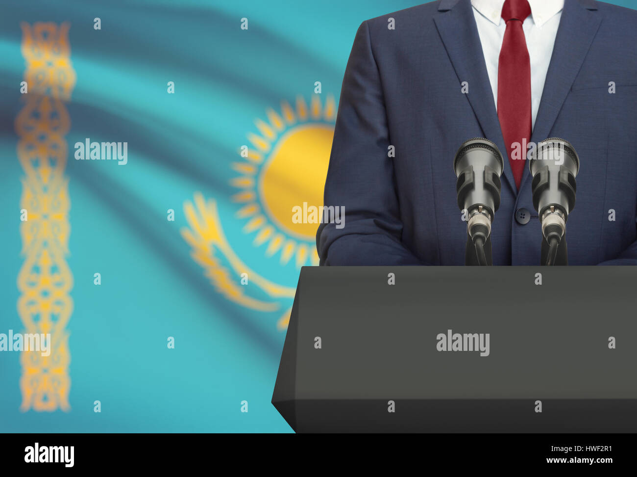 Businessman or politician making speech from behind the pulpit with national flag on background - Kazakhstan Stock Photo