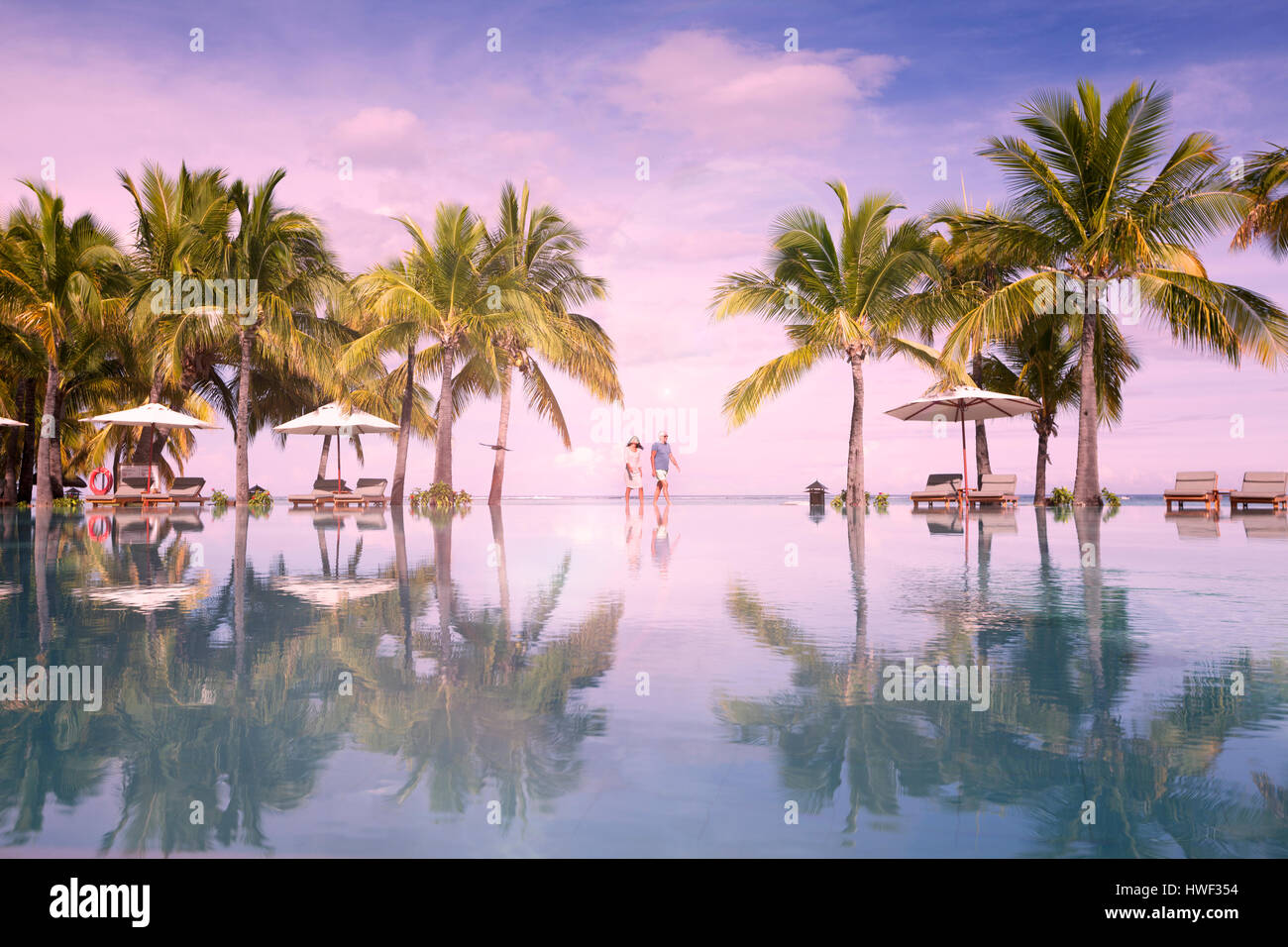 Honeymooners walking neer swimming pool. Luxurious five stars holiday resort on tropical paradise island Stock Photo